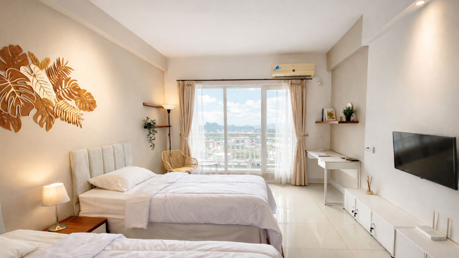Hasil jadi: kamar apartemen dengan dua tempat tidur putih, hiasan dinding daun monstera, meja kerja, dan TV