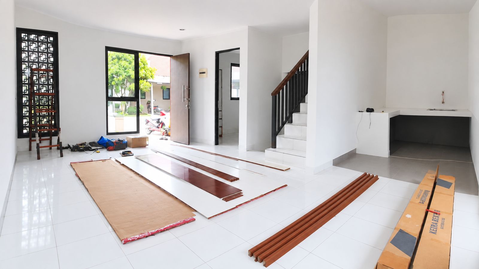 Sebelum: rumah baru dengan lantai keramik putih, bahan bangunan di lantai, pintu masuk, dan tangga